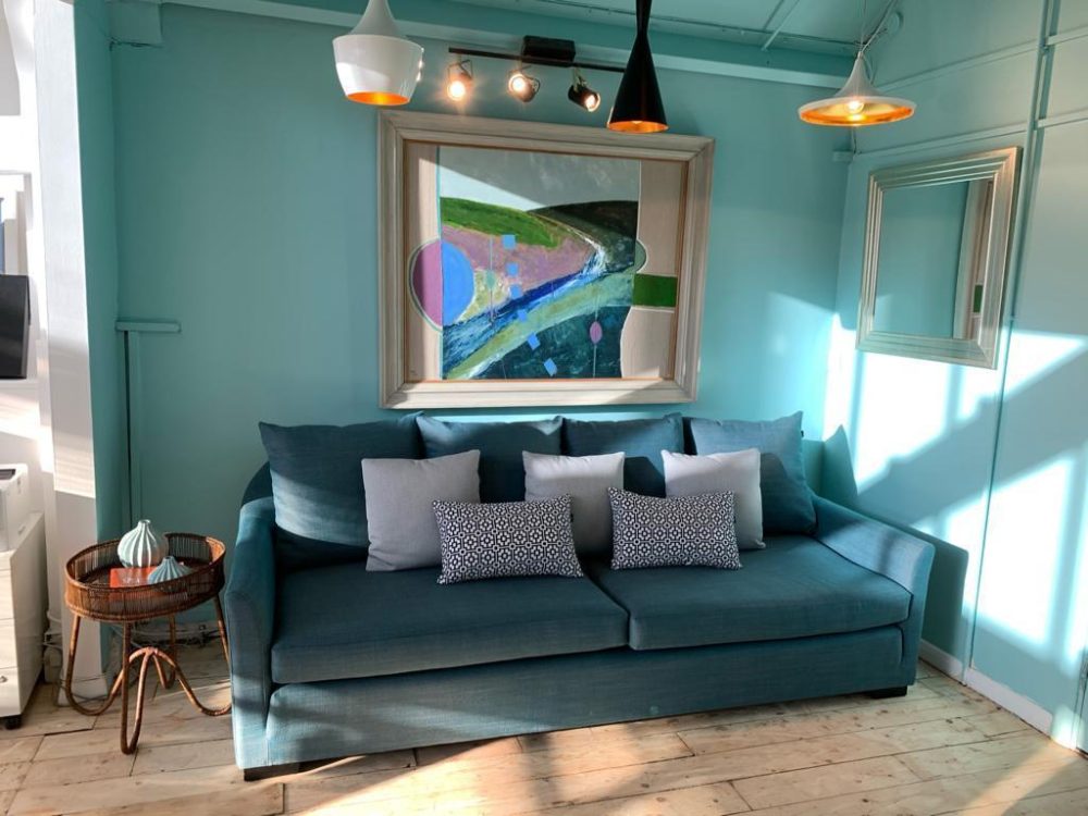 blue sofa with artwork behind it