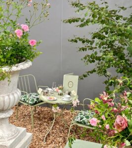 a table and chairs surrounded by flowers